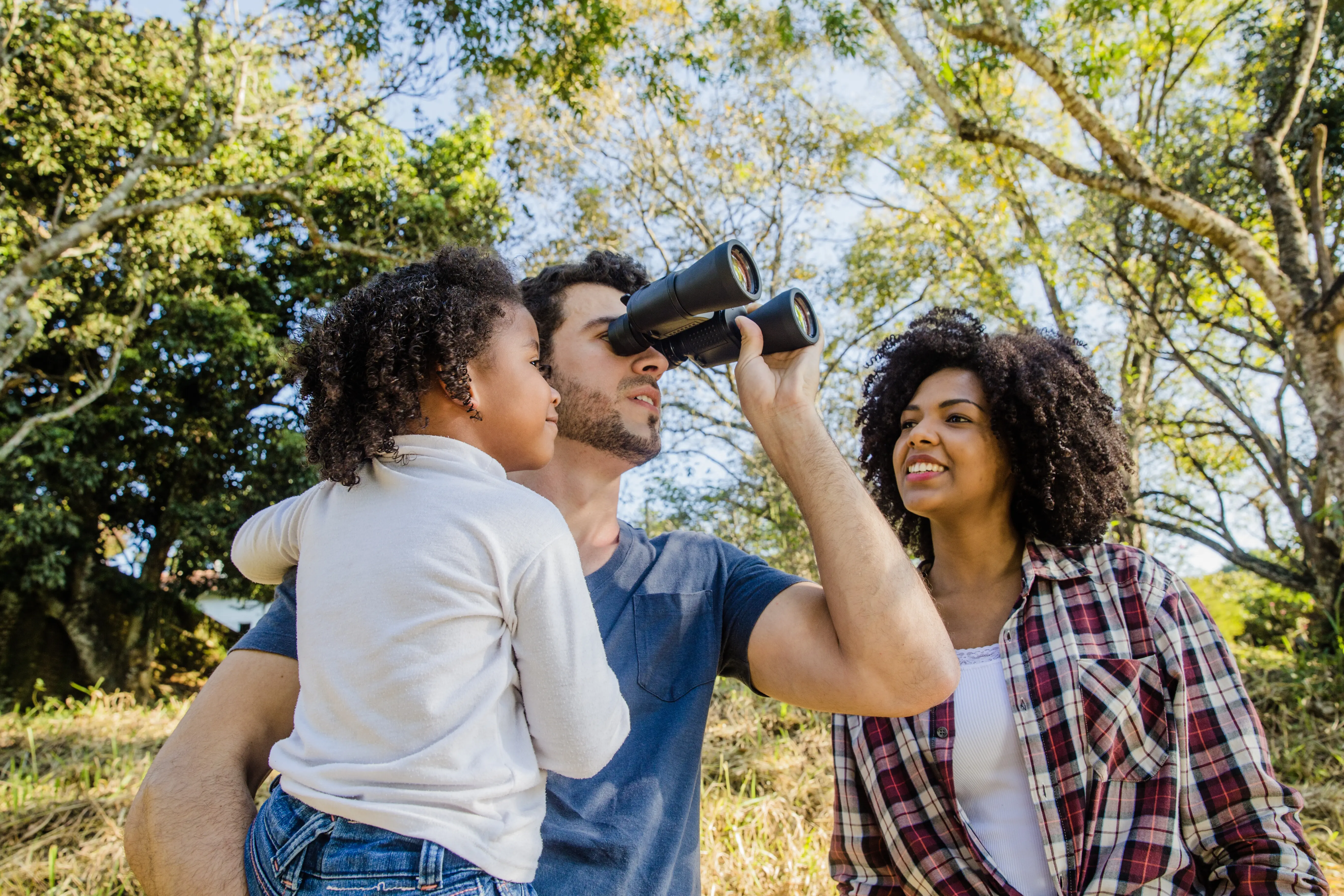 Vater blickt durch ein Fernglas.
